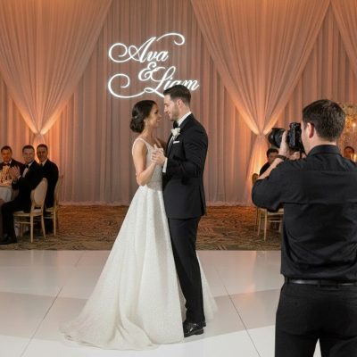 Couple dancing inside custom name light projection at Louisville wedding