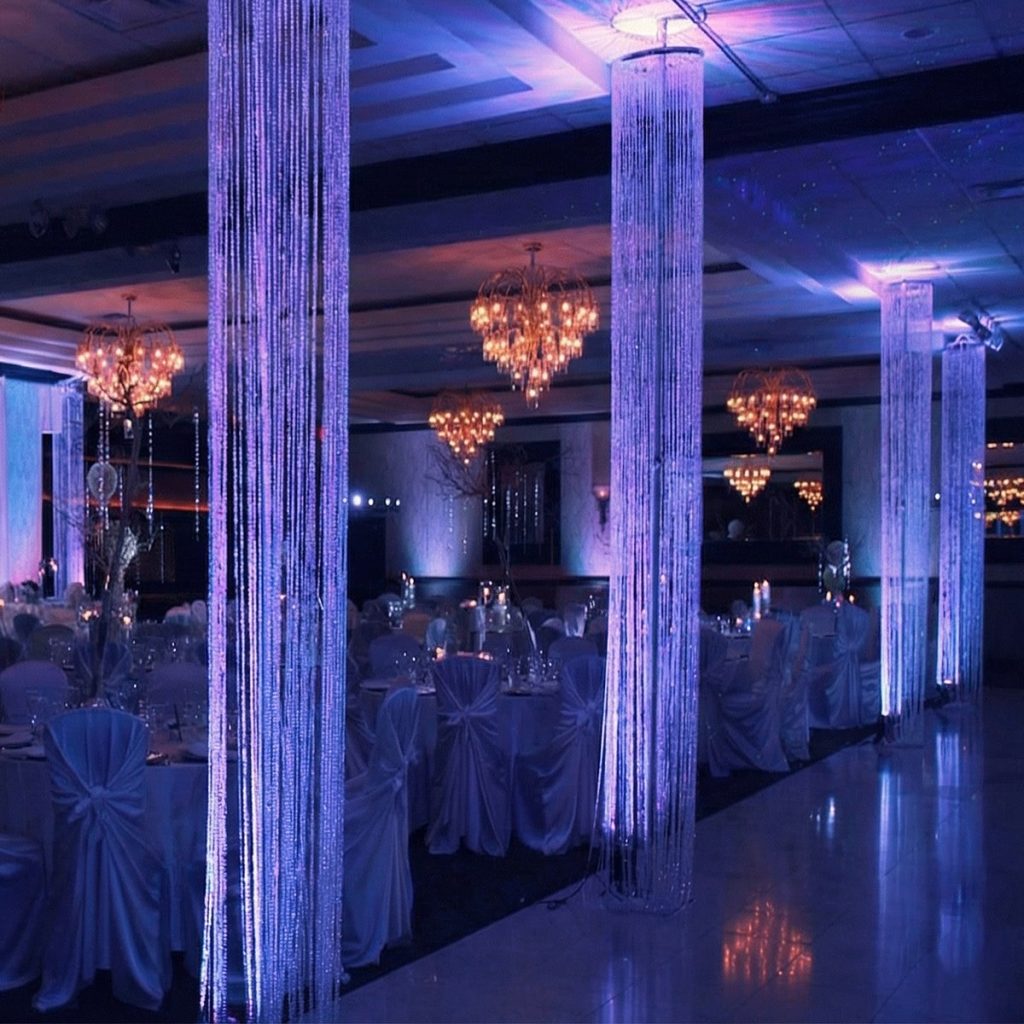 Crystal chandelier pillars dividing and decorating a large reception room