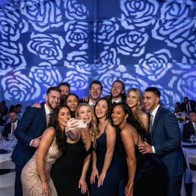 Wedding guests posing under breakup pattern lighting on dance floor
